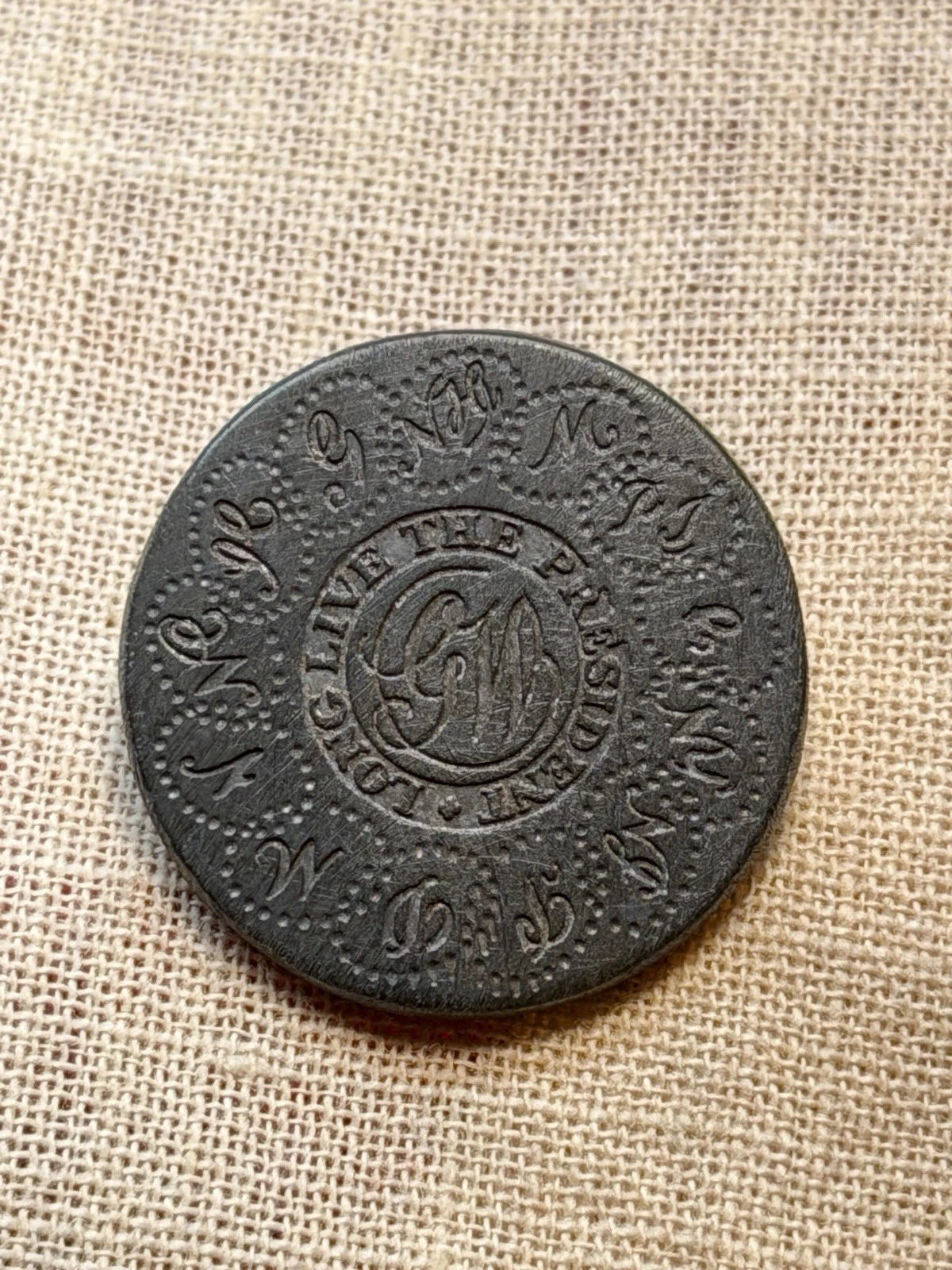 Suspect small-size button front showing uneven lettering